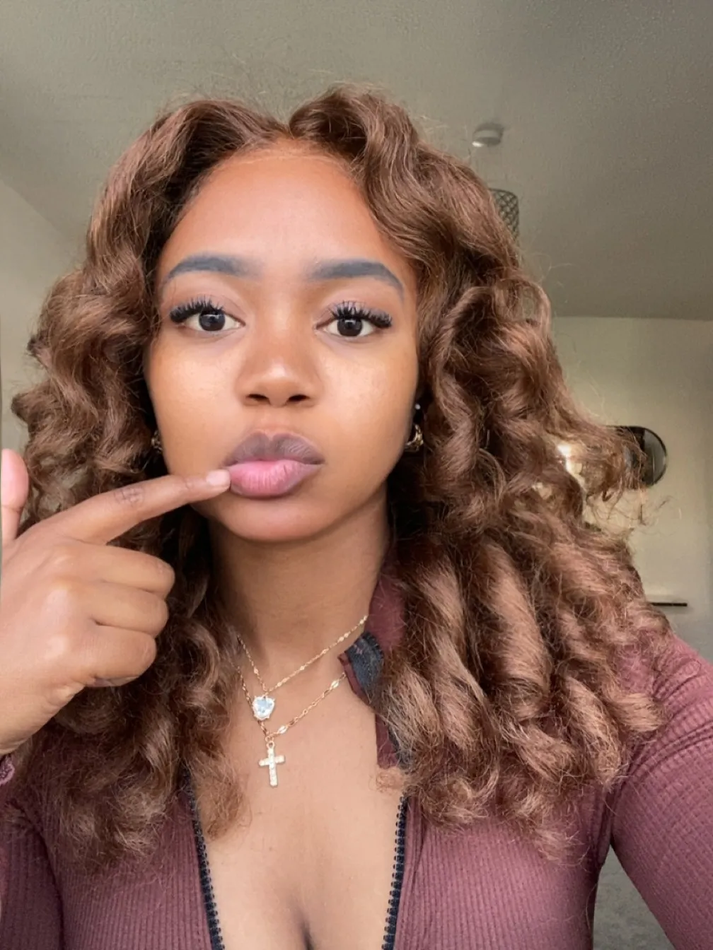 Chloe, Deep Tissue Therapist, maroon zip-top finger-to-lips portrait at All Queens Wellness Spa, Kindaruma Road, Kilimani, Nairobi.